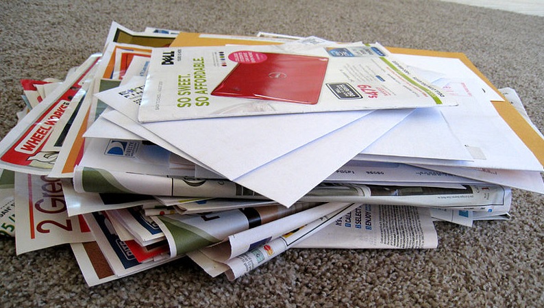 a pile of junk mail stacked in a disorderly way